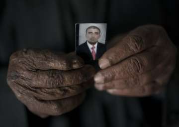 Ghanim Ahmed holds the photo of his son Ghazwan Ahmed, who was taken by unidentified gunmen after their village was liberated from ISIS militants, in Bijwaniya village, south of Mosul