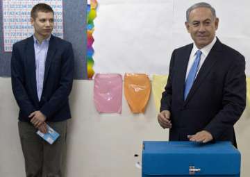 FILE - In this March 17, 2015 file photo, Benjamin Netanyahu casts his vote with his son Yair during Israel's parliamentary elections in Jerusalem