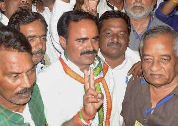 Congress candidate Brijendra Singh Yadav with his suporters flashes victory sign after winning Mungaoli by-polls state assembly elections, in Ashok Nagar District Madhya Pradesh on Wednesday. 