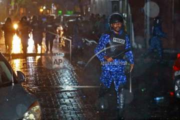 A Maldives policeman charges with baton towards protesters after the government declared a 15-day state of emergency in Male, Maldives, early Tuesday on February 6, 2018.