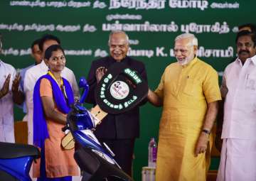 PM Modi launching TN govt's Amma scooter scheme for working women by handing over a vehicle to a beneficiary in Chennai on Saturday.