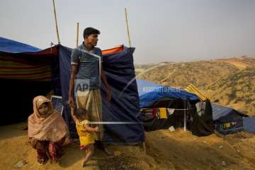 In this Jan. 14, 2018 photo, Rohingya Muslim refugee Mohammad Younus, 25, from the Myanmar village of Gu Dar Pyin, stands on a hill of Kutupalong refugee camp, Bangladesh.