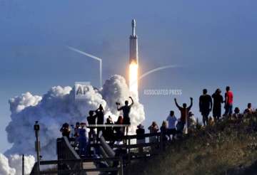 The crowd cheers at Playalinda Beach in the Canaveral National Seashore, just north of the Kennedy Space Center, during the successful launch of the SpaceX Falcon Heavy rocket, Tuesday, February 6, 2018.