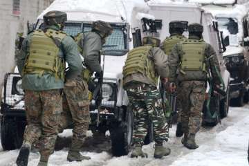 Security personnel take positions during an encounter with the militants who were sheltering in a building near a CRPF camp at Karan Nagar, in Srinagar on Monday. 