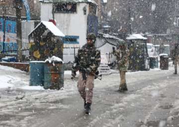 CRPF personnel conduct search operations amid snowfall after two militants were spotted by an alert sentry at the observation post of 23rd battalion of the CRPF in Karan Nagar area of Srinagar on Feb 12