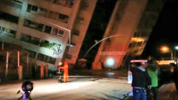 Emergency services attend after a building collapsed onto it's side, following an earthquake in Hualien County, eastern Taiwan, early Wednesday, February 7, 2018.