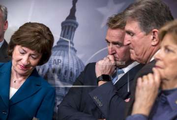 From left, Sen. Susan Collins, R-Maine, Sen. Jeff Flake, R-Ariz., Sen. Joe Manchin, D-W.Va., and Sen. Jeanne Shaheen, D-N.H., finish a news conference on the bipartisan immigration deal they reached during a news conference at the Capitol in Washington on Thursday February 15, 2018. 
