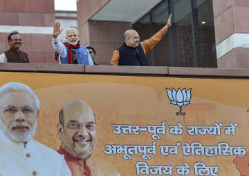 Prime Minister Narendra Modi and BJP President Amit Shah wave as they arrive to address BJP party workers after their victory in North-East Assembly election at party headquarters in New Delhi on Saturday. 