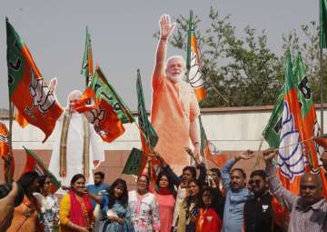 BJP workers celebrate the party's performance in the recently concluded Tripura and Nagaland assembly elections at the party's headquarters in New Delhi