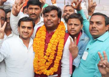 Samajwadi Party candidate Praveen Kumar Nishad flashes victory sign after his success in the bypoll elections, in Gorakhpur on Wednesday.