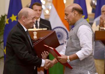 Home Minister Rajnath Singh exchanges documents with French Foreign Affairs Minister Jean-Yves Le Drian, as Prime Minister Narendra Modi and French President Emmanuel Macron look on, at Hyderabad House in New Delhi on Saturday.