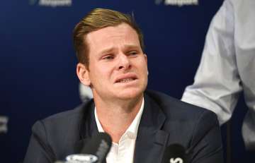 Steve Smith breaks during a press conference at Sydney International Airport 