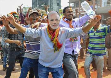 BJP supporters wear a mask of Prime Minister Narendra Modi to celebrate party's victory in Tripura Assembly elections in Agartala on Saturday.