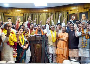 Uttar Pradesh Chief Minister Yogi Adityanath flashes the victory sign with newly elected BJP MP's of Rajya Sabha after BJP wins 9 seats in UP, in Lucknow on Friday.
