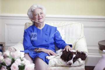 In this 1990 file photo, first lady Barbara Bush poses with her dog Millie in Washington. 