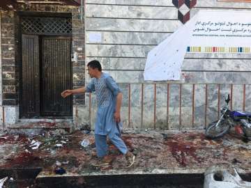 An Afghan man walks outside a voter registration center, which was attacked by a suicide bomber in K