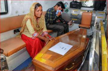 Family members mourn near a casket containing remains of one of the Indians abducted by the Islamic State group in 2014, that were found in a mass grave outside Mosul in Amritsar on Monday.