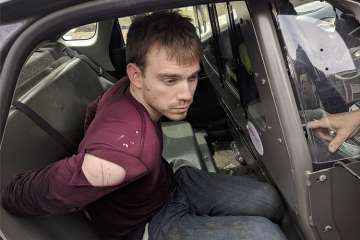 In this photo released by the Metro Nashville Police Department, Travis Reinking sits in a police car after being arrested in Nashville.