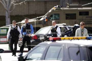 Armed law enforcement personnel exit YouTube headquarters, Tuesday, April 3, 2018, in San Bruno, California.