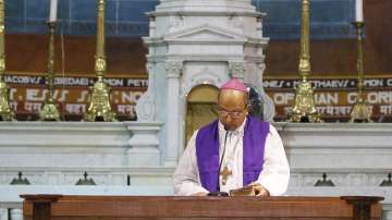 Archbishop of Delhi, Anil Couto, reads from a holy book during a service on Good Friday at the Sacred Heart Cathedral in New Delhi.