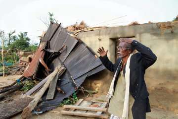 A man reacts near his damaged house after a cyclone hit Belchharra village at Khowai district of Tripura on Monday.