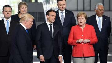 This file photo taken on May 25, 2017 shows French President Emmanuel Macron (2nd L) and German Chancellor Angela Merkel (R) speaking as US President Donald Trump (front L) arrives for a family picture during the NATO (North Atlantic Treaty Organization) summit at the NATO headquarters, in Brussels.