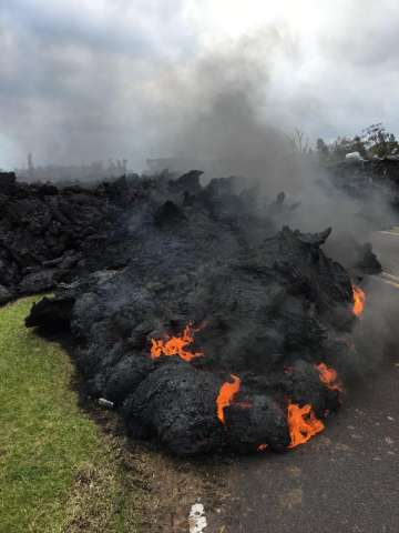 Lava burns across the road in the Leilani Estates in Pahoa, Hawaii, Saturday, May 5, 2018. Hundreds of anxious residents on the Big Island of Hawaii hunkered down Saturday for what could be weeks or months of upheaval as the dangers from an erupting Kilauea volcano continued to grow.