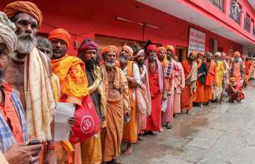 Sadhus wait in a queue to get themselves registered for Amarnath Yatra at a base camp, in Jammu on Saturday.