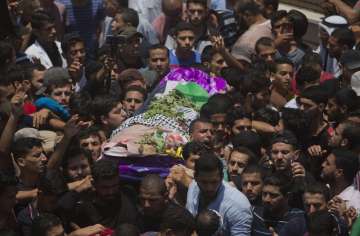 Palestinian mourners carry the body of a volunteer paramedic Razan Najjar, 21, during her funeral in town of Khan Younis, Southern Gaza Strip