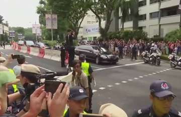 Kim Jong un zipped through Singapore streets in a black limosuine with North Korean flag as thousands of journlaist stood by