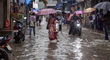 Thane: People walk through a water-logged street after heavy rains