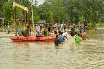 Tripura State Rifles personnel travel on a boat through a flooded street after rescuing flood-affected residents, in Kailashahar on Friday.