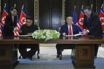  
North Korea leader Kim Jong Un and US President Donald Trump prepare to sign a document at the Capella resort on Sentosa Island onm Tuesday