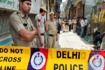 Police near the house, where 11 members of a family were found hanging from an iron grill, in New Delhi.
 