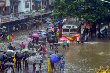 People wade through a waterlogged street following heavy rains, in Mumbai on Tuesday.