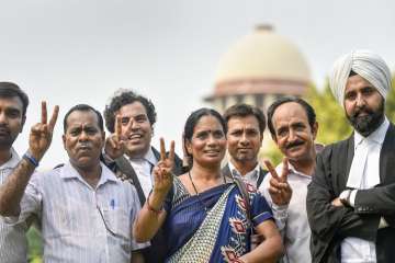 Nirbhaya's parents show victory sign after the Supreme Court's verdict on Dec 2012 gang rape case, in New Delhi on Monday.