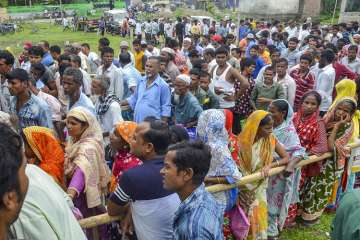 People wait to check their names on the final draft of the state's National Register of Citizens after it was released, at an NRC Seva Kendra in Tezpur on Monday.