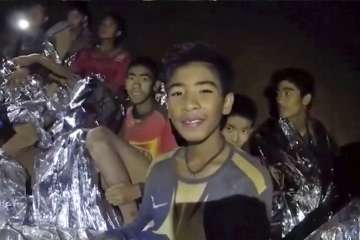 Thai boys smile as Thai Navy SEAL medic help injured children inside a cave in Mae Sai, northern Tha