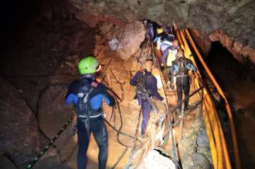 Thai rescue team members walk inside a cave where 12 boys and their soccer coach have been trapped since June 23, in Mae Sai, Chiang Rai province, northern Thailand.?