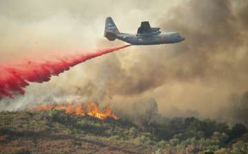 A US Air Force plane drops fire retardant on a burning hillside in the Ranch Fire in Clearlake Oaks, Calif., Sunday, Aug 5, 2018. 