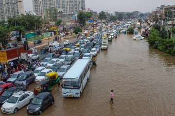 Vehicle wade through a waterlogged road at Subhash Chowk after heavy rains in Gurugram.