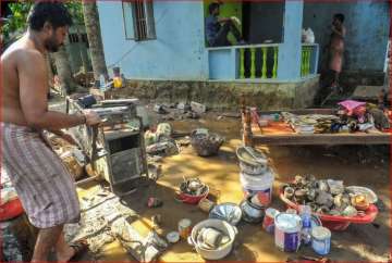 A man cleans up his house after flood water subsided at Chengannur district of the Kerala