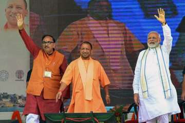 Prime Minister Narendra Modi (R), Uttar Pradesh Chief Minister Yogi Adityanath and UP BJP chief Mahendra Nath Pandey (L) during the inauguration of various development projects, in Varanasi.