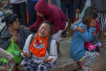 Residents react as a body of a tsunami victim is recovered in a village heavily damaged by Friday's tsunami in Palu, Central Sulawesi, Indonesia on Oct 3, 2018. (AP Photo)