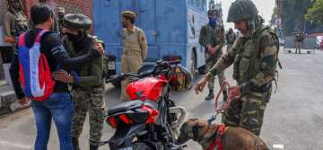 Srinagar: CRPF personnel check vehicles and motorcycles using sniffer dogs, ahead of polling for first phase of elections for urban local bodies in Kashmir, in Srinagar, Saturday, Oct 6, 2018.