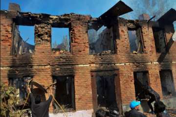 Kulgam: People clearing debris from the damaged house where militants were hiding during an encounter, at Kulgam district of South Kashmir, Sunday, Oct 21, 2018. The police claim that the blast took place when people touched the ammunition left behind by dead terrorists.