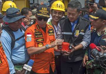  
TV showed footage of two divers after they surfaced, swimming to an inflatable vessel and placing the bright orange device into a large container that was transferred to a search-and-rescue ship.