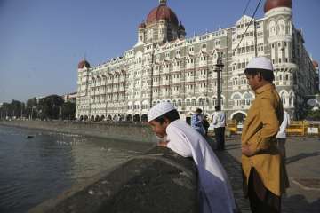 Two boys stand outside the iconic Taj Mahal Palace hotel, the epicenter of the 2008 terror attacks that killed 166 people in Mumbai, India. Thirty-one people died inside the hotel, including staff trying to guide the guests to safety. Visceral images of smoke leaping out of the city landmark have come to define the 60-hour siege.
 