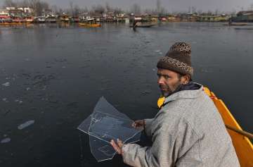 A boatman holds ice flakes from the partially frozen Dal Lake in Srinagar