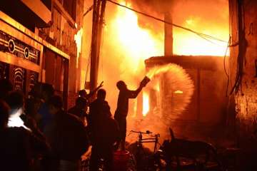 Firefighters and local people help to douse a fire in Dhaka, Bangladesh